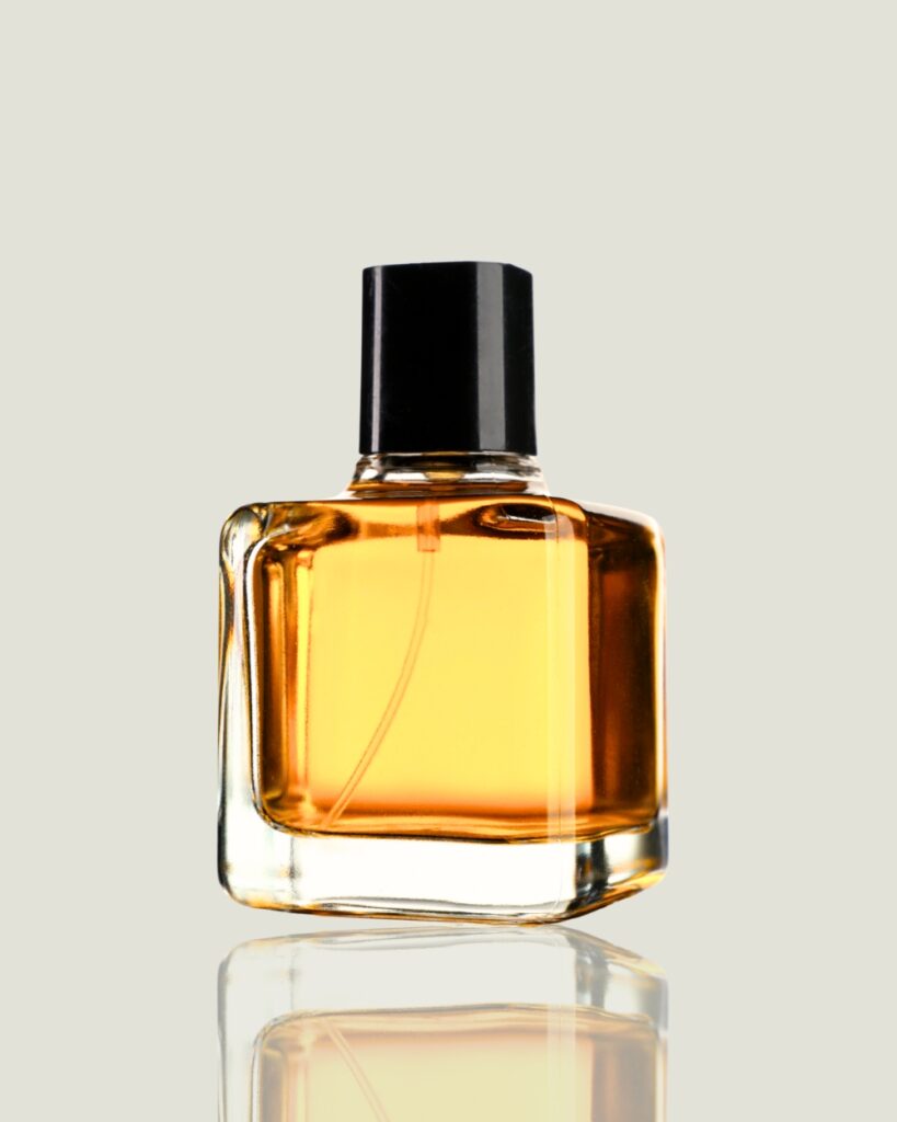 Minimalistischer Glasflakon mit goldener Parfüm-Essenz vor hellem Hintergrund, der die Exklusivität und Qualität der Duftberatung unterstreicht.